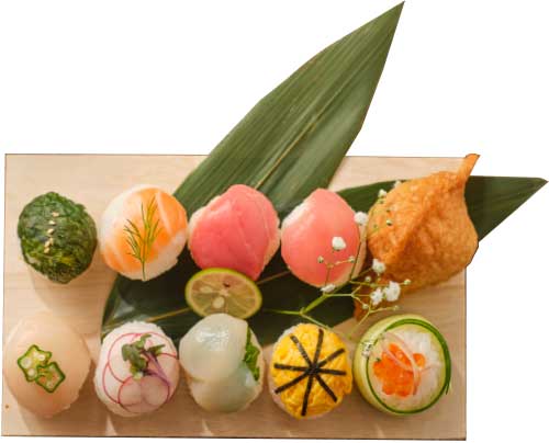 竹の葉の上に置かれた、色鮮やかな創作手毬寿司の盛り合わせ